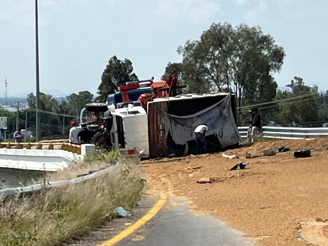 Vuelca camión cargado con alimento para ganado en el acceso a San Juan del Río Vuelca camión cargado con alimento para ganado en el acceso a San Juan del Río